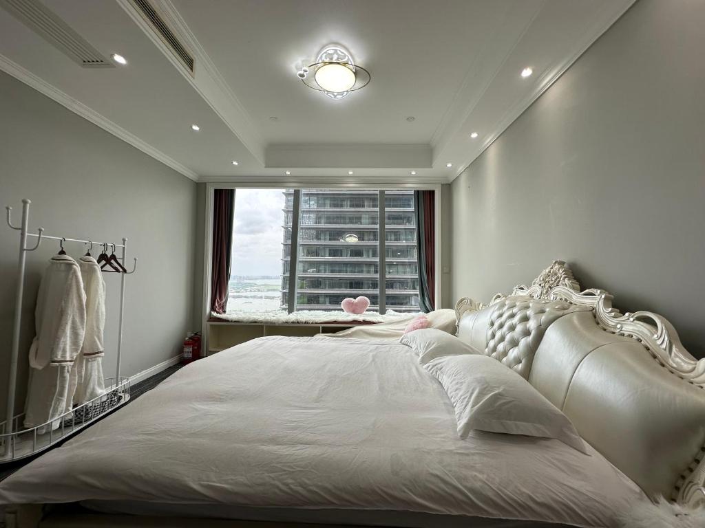 苏州苏州东方之门湖景公寓的卧室配有一张大白色床和窗户