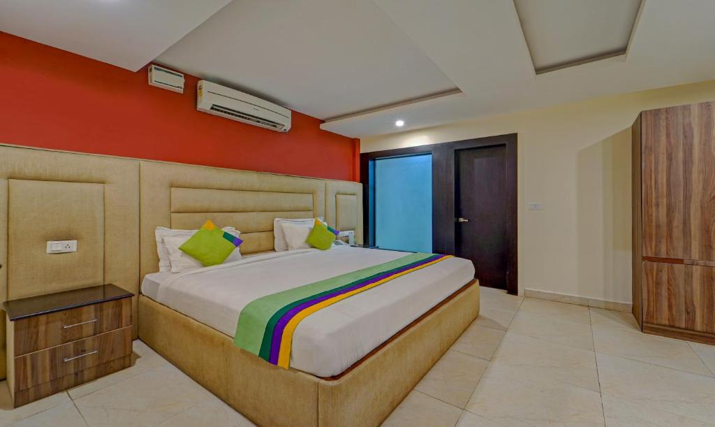 钦奈Treebo Trend Elan的一间卧室配有一张带橙色墙壁的大床