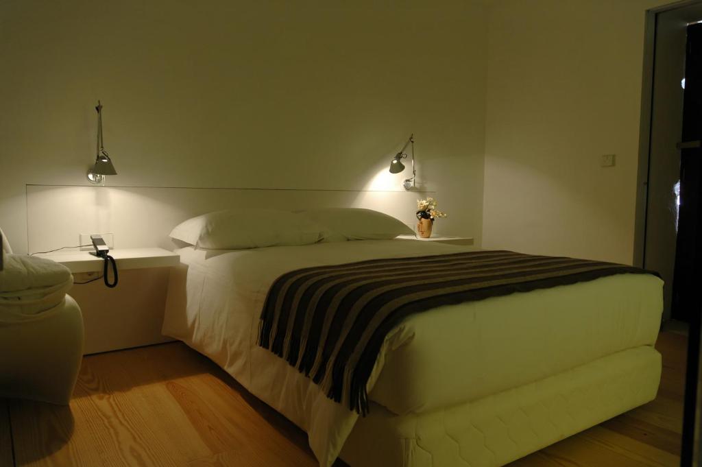 布拉加提巴斯修道院酒店的一间卧室配有一张大床,两盏灯