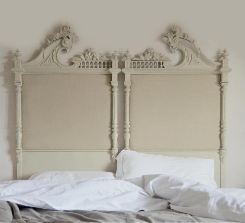 福贾B&B La Casa Pugliese的一张带白色床头板和白色床单的床