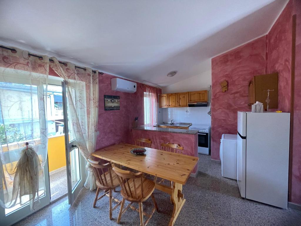 拉契亚Dimora Pina sul mare的厨房配有木桌和冰箱。