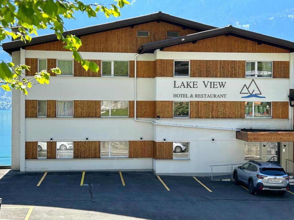 因特拉肯Hotel Lakeview bei Interlaken的停车场内有停车位的建筑物