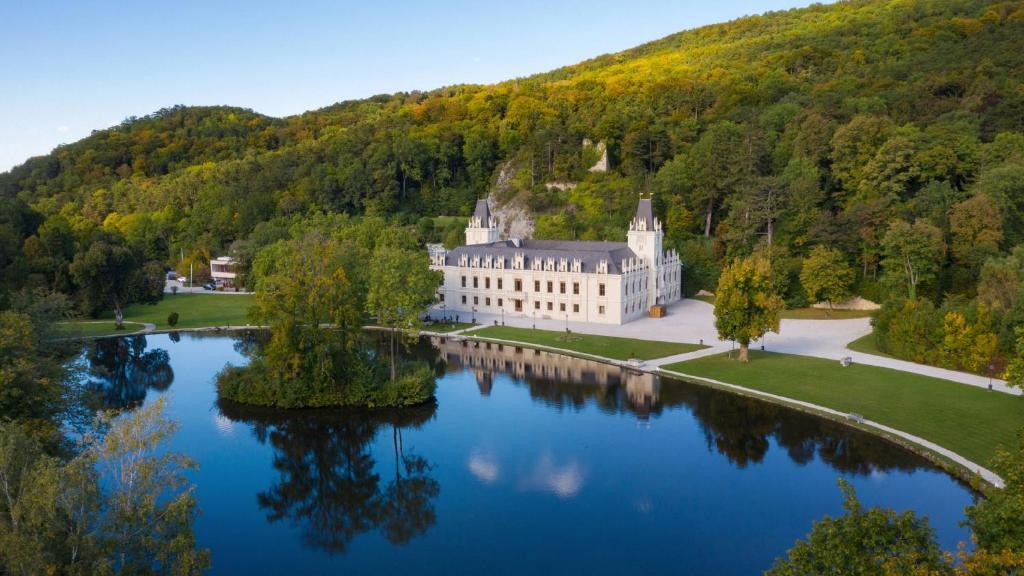 HernsteinHotel Schloss Hernstein的享有湖泊上城堡的空中景致