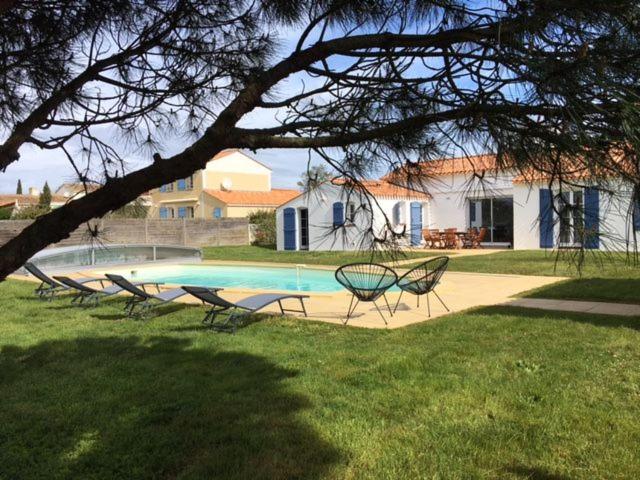 莱居永叙尔维Gite avec piscine privative的一组椅子坐在游泳池周围