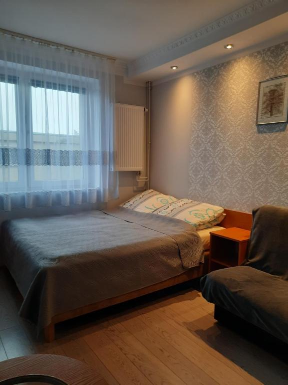 米兹多洛杰Willa Kamako的一间卧室设有一张床、一个窗口和一把椅子