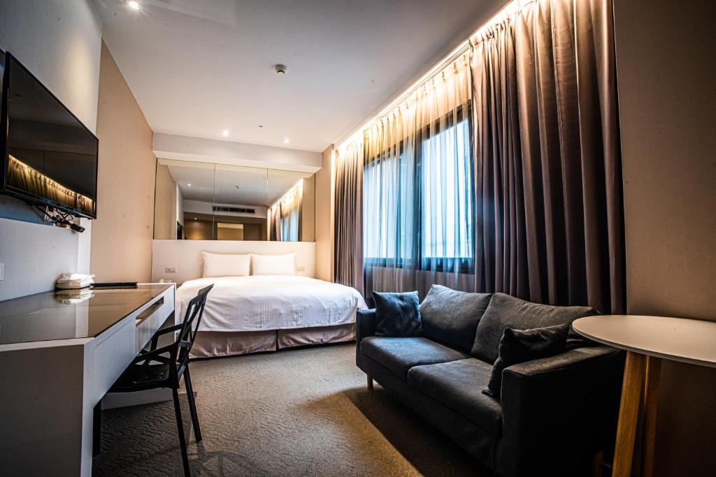 台北Artinn藝築文旅-台北站前館的酒店客房,配有床和沙发