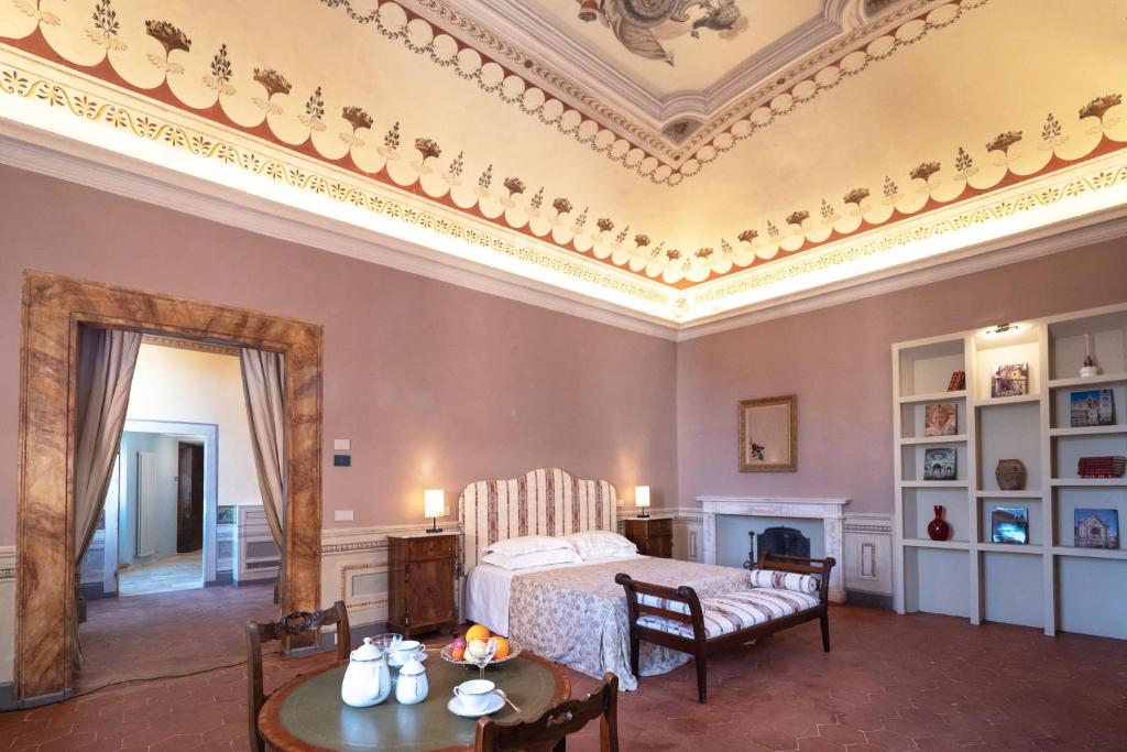 蒙特普齐亚诺Delcorto Suites的卧室配有一张床和一张桌子及椅子