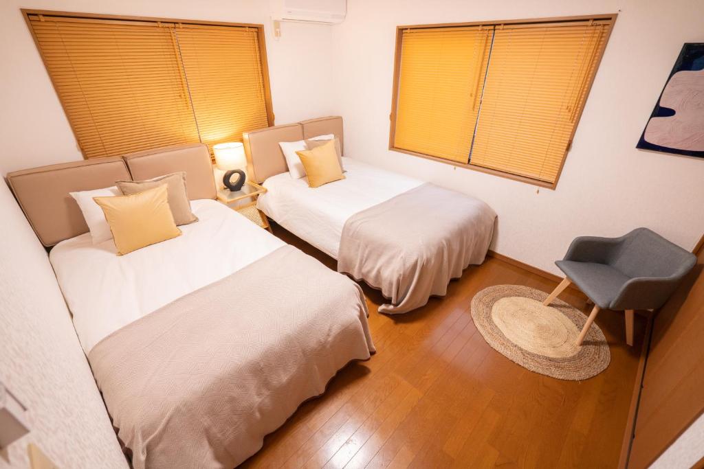 东京HANAMIKAKU-shinjuku/akihabara/asakusa/ginza/tokyo/narita/haneta Japanese House 100㎡的一间设有两张床和椅子的房间
