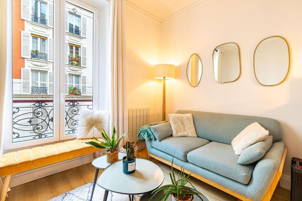 巴黎GuestReady - Lovely urban retreat in the 17th Arr.的带沙发和窗户的客厅