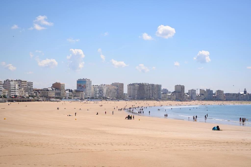 莱萨布勒-多洛讷La Maison des sables , 300m de la plage的一群人,在海边