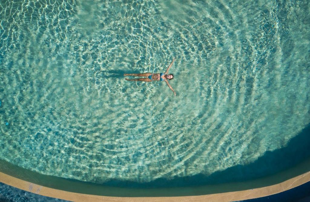 伊亚Danae Suites Santorini的在海洋中游泳的人