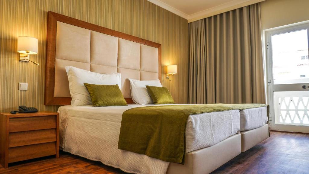 蒙蒂戈杜巴艾德蒙特哥酒店的一间卧室配有一张大床和大床头板