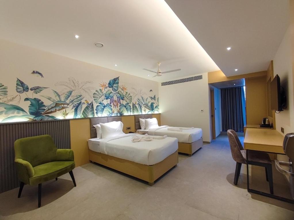 维沙卡帕特南Signature Hotels的酒店客房带两张床和一张桌子以及椅子。