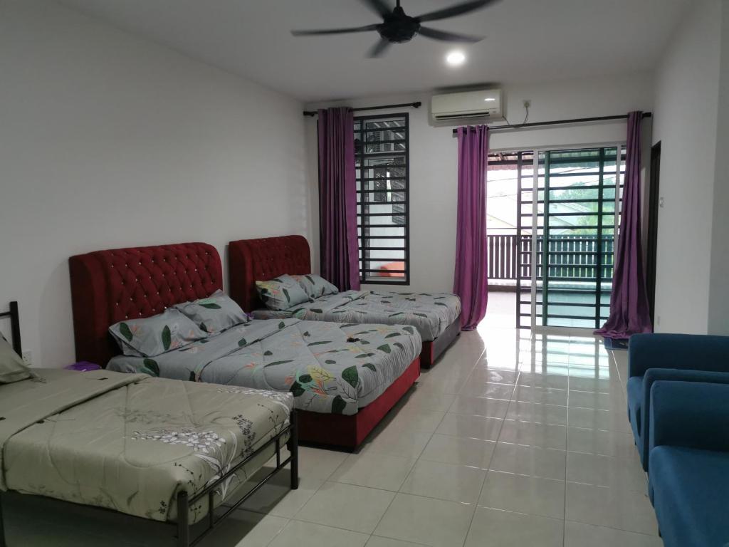 关丹cs homestay的客房设有三张床和吊扇。