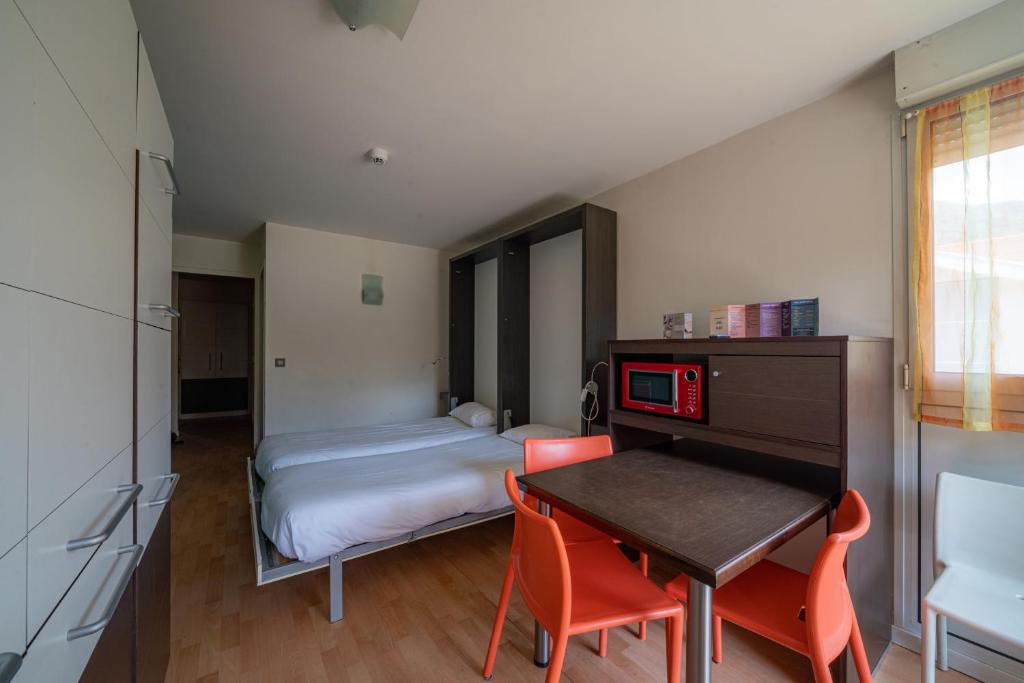 拉里歇尔Residence RADIANA的一间卧室配有一张床、一张桌子和一张桌子