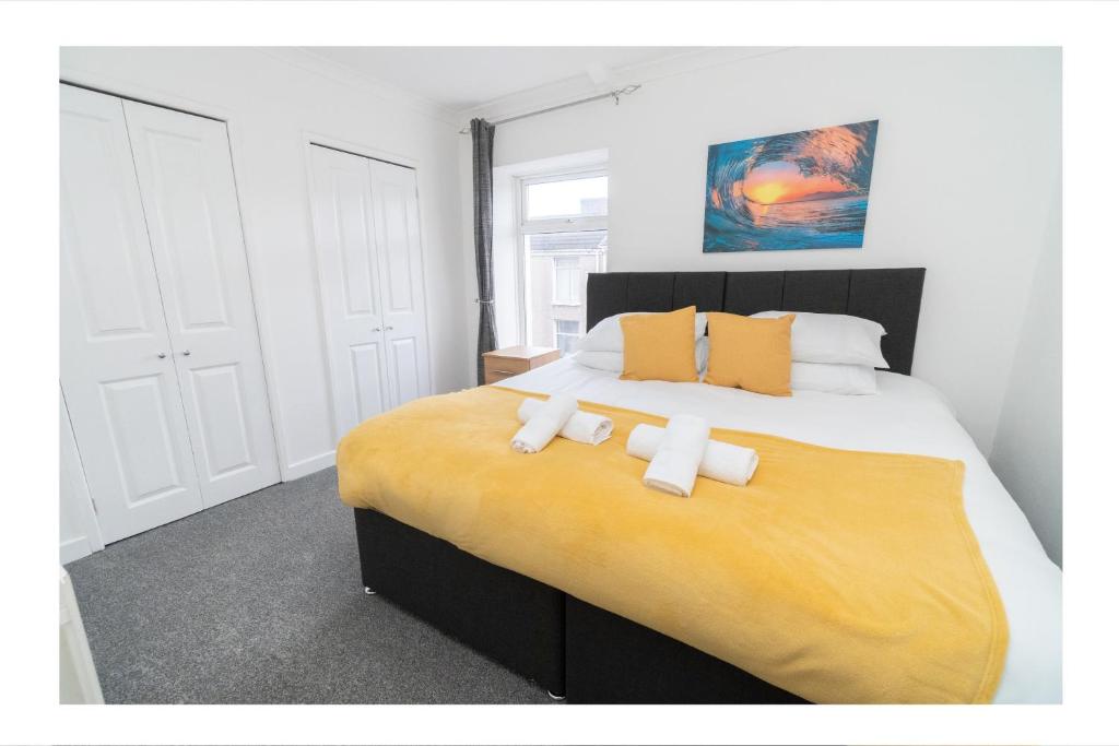斯旺西Business friendly 3BR home - King size beds & Centrally located的一间卧室配有一张大床和两条毛巾