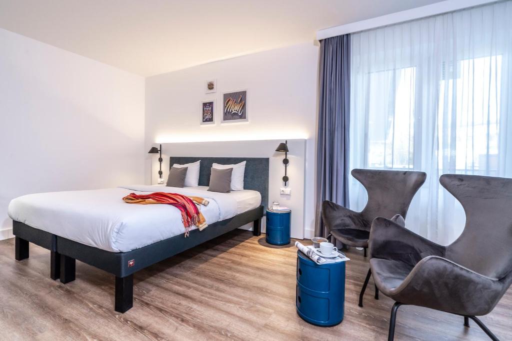 汉堡汉堡阿尔斯特市宜必思风格酒店的酒店客房,配有一张床和两把椅子