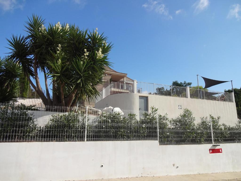 TurísLAS PALOMAS, appartement 3 chambres avec piscine的白色的建筑,有围栏和棕榈树