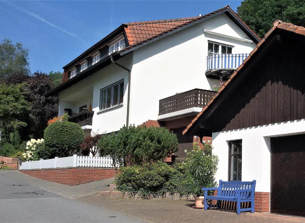 LeonhardshofFerienwohnung Haus Sommerberg的前面有蓝色长椅的白色房子