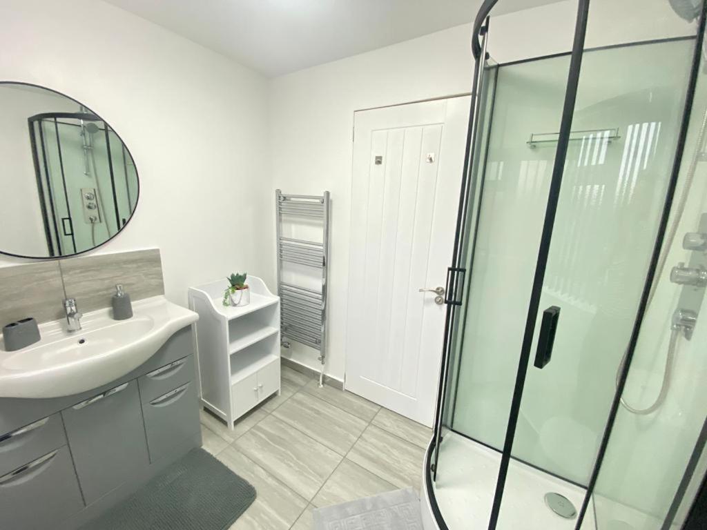霍利Gatwick Deluxe En-suite Rooms的白色的浴室设有水槽和淋浴。