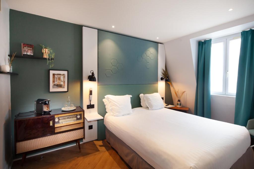 巴黎旺多姆圣日耳曼酒店的卧室配有一张白色大床和一张书桌