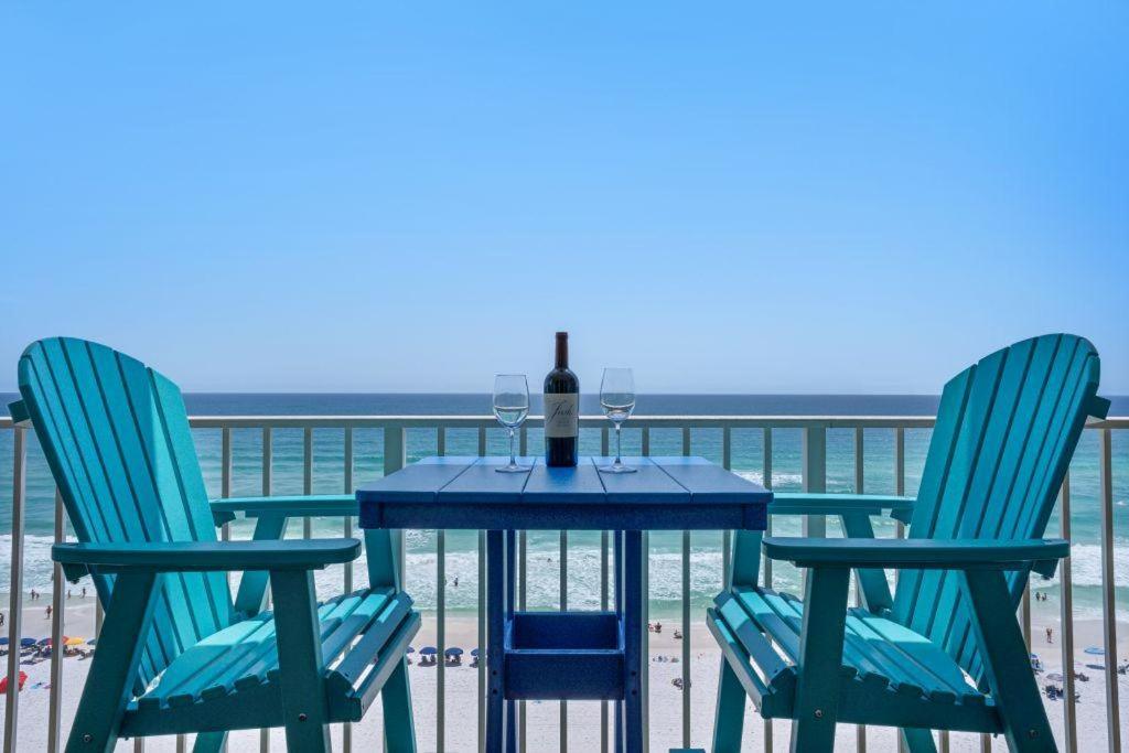 德斯坦Majestic Sun 806B的海滩上的一张桌子、一瓶葡萄酒和两把椅子