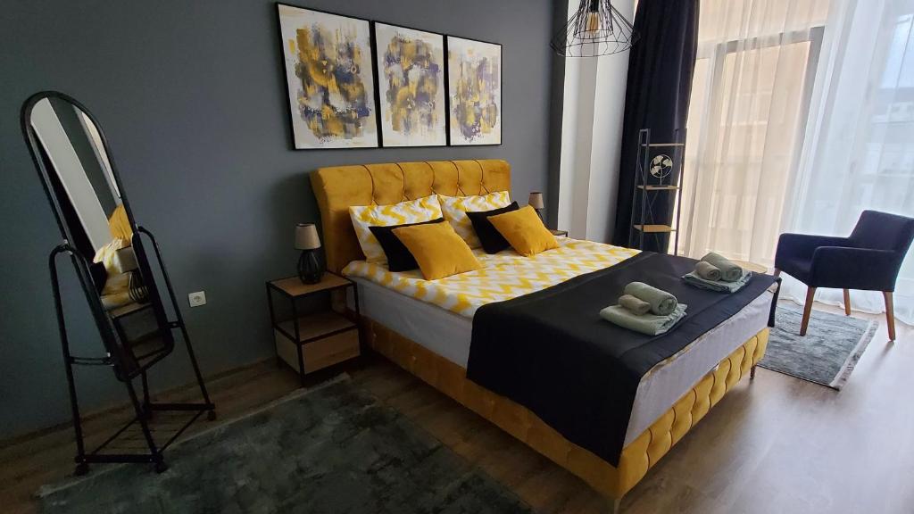 布戈伊诺Apartman Gold的一间卧室配有一张带黄色枕头和镜子的床