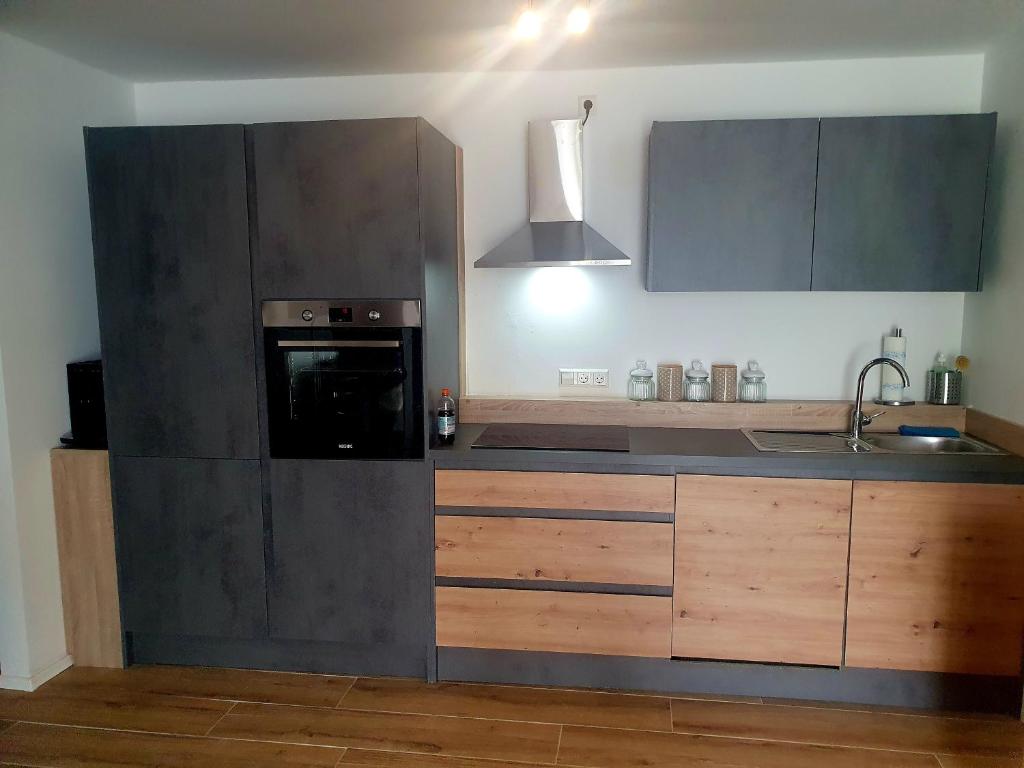 梅德巴赫Nivis的厨房配有木制橱柜、水槽和微波炉