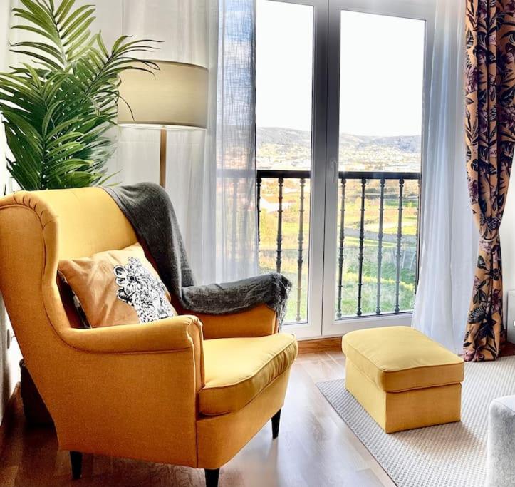 费罗尔Artabra Infinita Petit Home的客厅配有椅子和大窗户