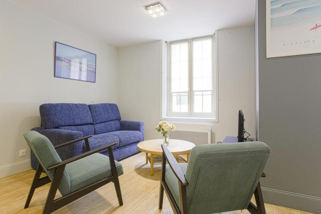 比亚里茨Nice flat 300 meters away from the beach - Biarritz - Welkeys的客厅配有蓝色的沙发和桌子