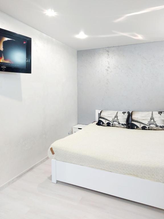 尼古拉耶夫Lux apartment Sadovaya street的白色卧室设有一张床和墙上的电视