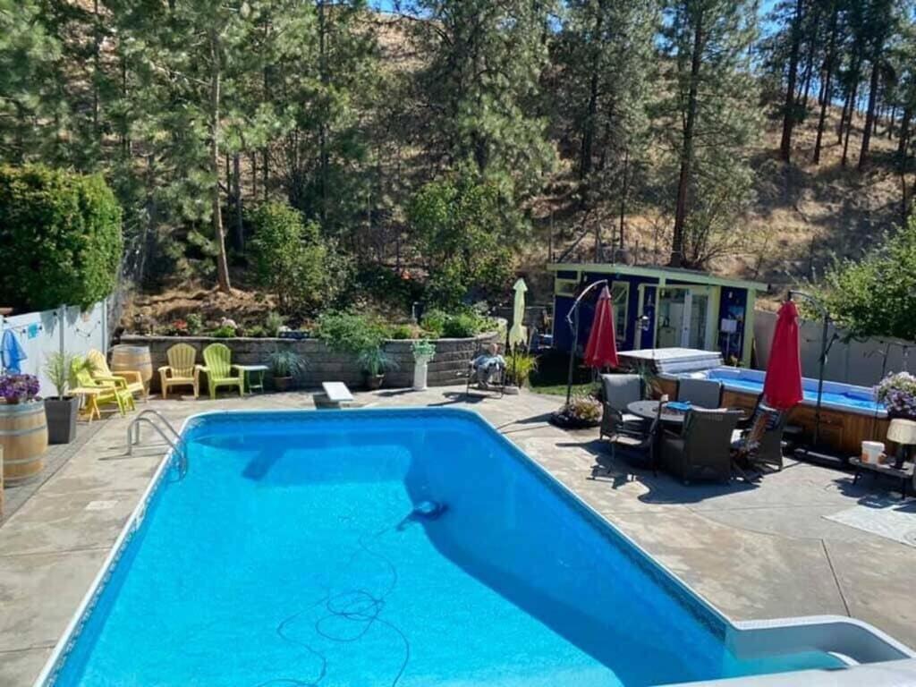 彭蒂克顿Okanagan Saltwater Pool & Swimspa Oasis的庭院中的游泳池,庭院和房子