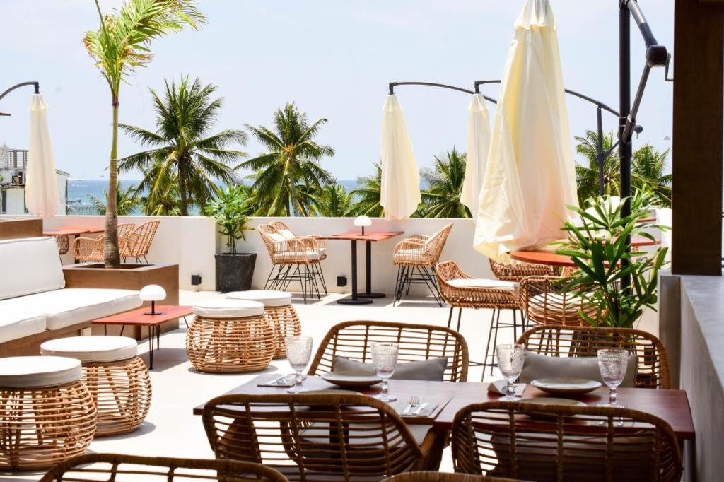 长滩岛Serene La Playa Boracay的一个带桌椅和遮阳伞的户外庭院。