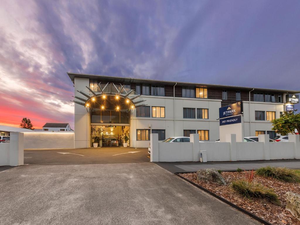 罗托鲁瓦JetPark Hotel Rotorua的一座大型白色建筑,设有停车场