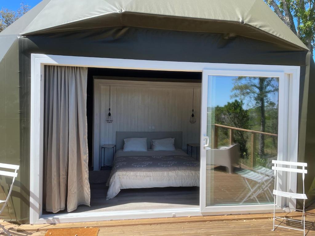阿尔热祖尔Nature Nest Aljezur的帐篷内的卧室,甲板上配有一张床