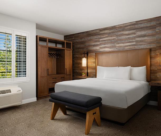 纳帕纳帕酒庄酒店的卧室配有一张白色的大床和凳子