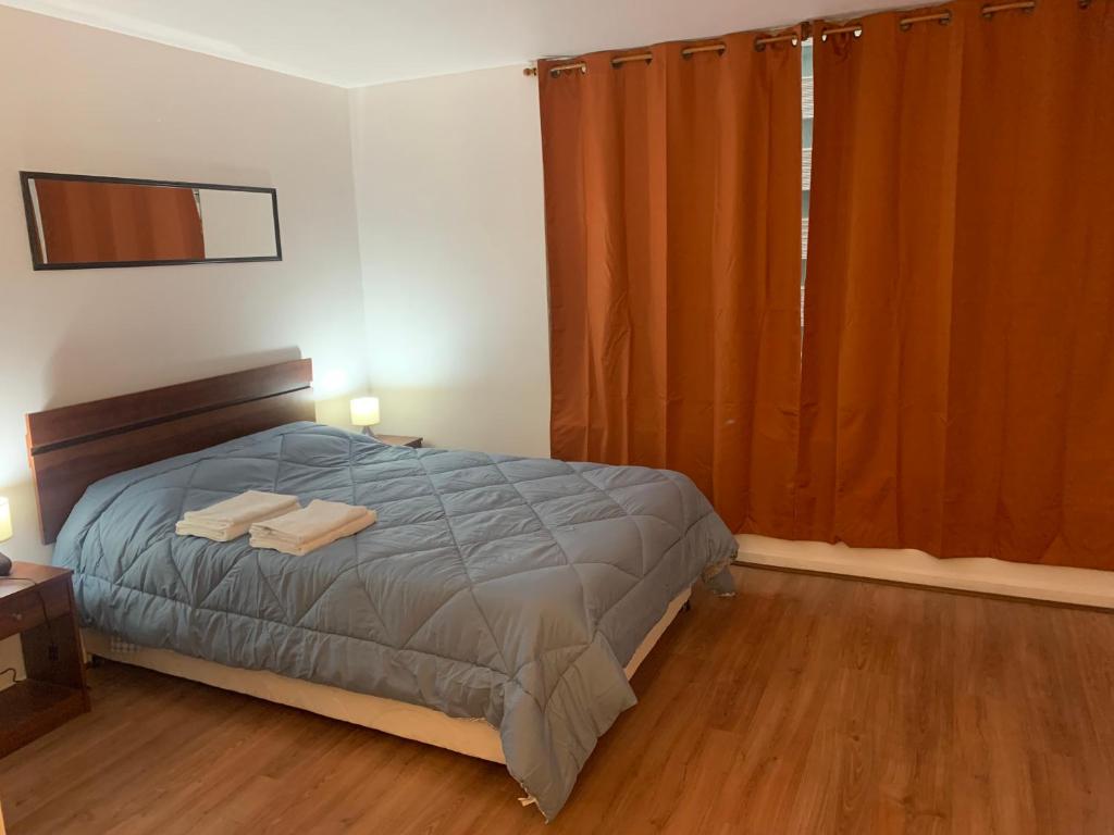 圣地亚哥A 100 pasos de la Alameda 45910的一间卧室配有床和橙色窗帘的窗户