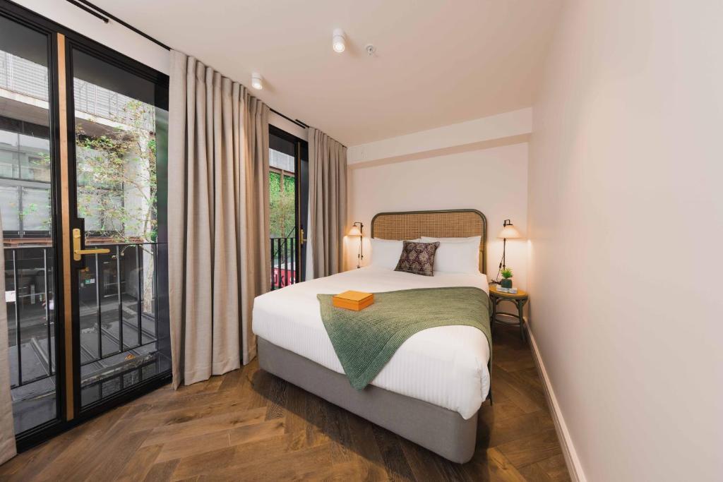 悉尼The Sarah by Urban Rest的一间卧室设有一张床和一个大窗户