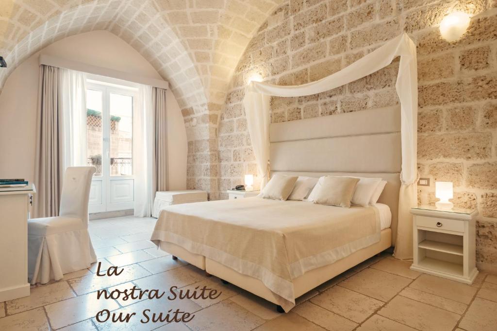 塔兰托Hotel L'Arcangelo - Boutique Hotel的一间卧室设有一张床和石墙