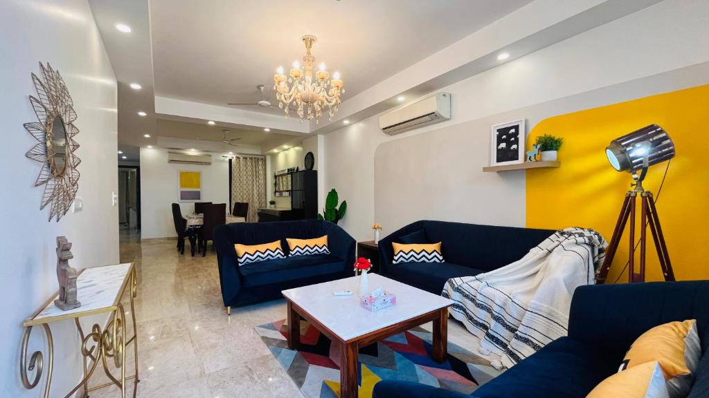 新德里大凯拉什奥利弗服务式公寓的客厅配有蓝色的沙发和桌子