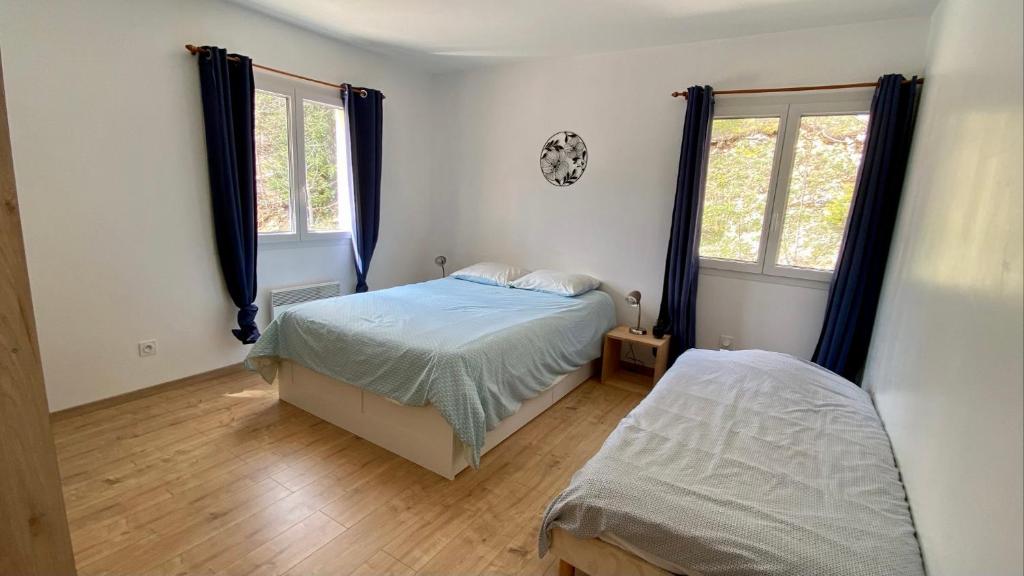 普雷芒翁Appartement idéal pour été et hiver, situé au pied des pistes de ski et des sentiers de randonnée的一间卧室设有两张床和两个窗户。