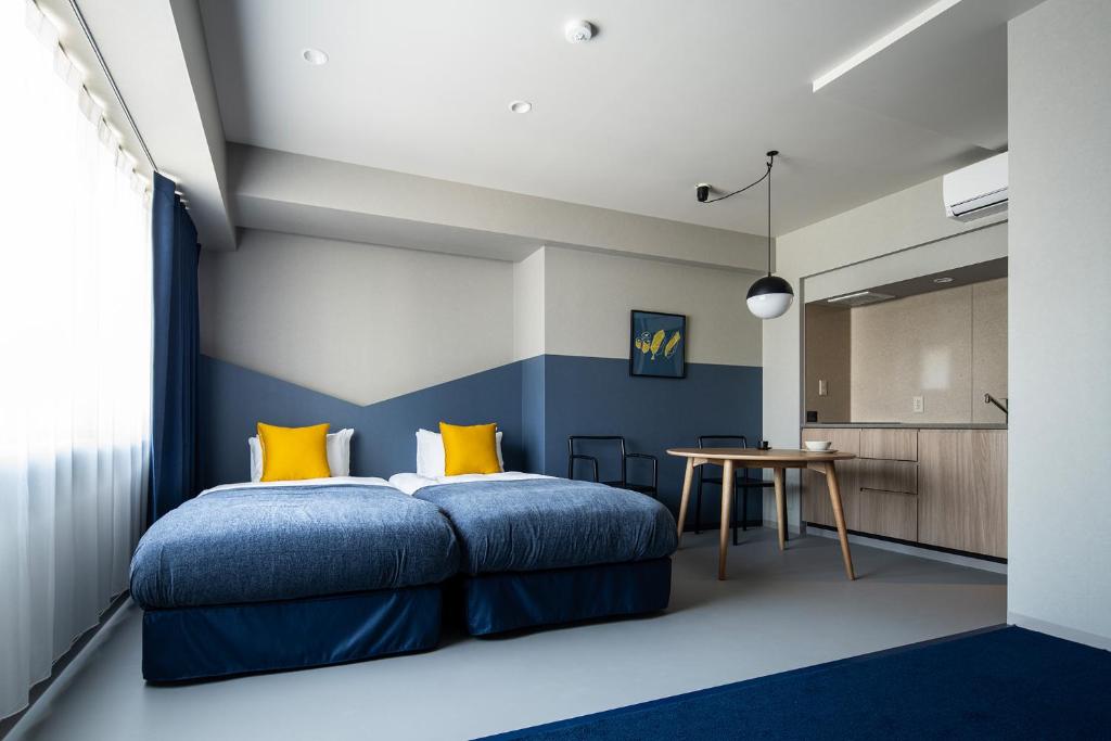 东京Section L Tsukiji的一间卧室配有蓝色和黄色枕头的床
