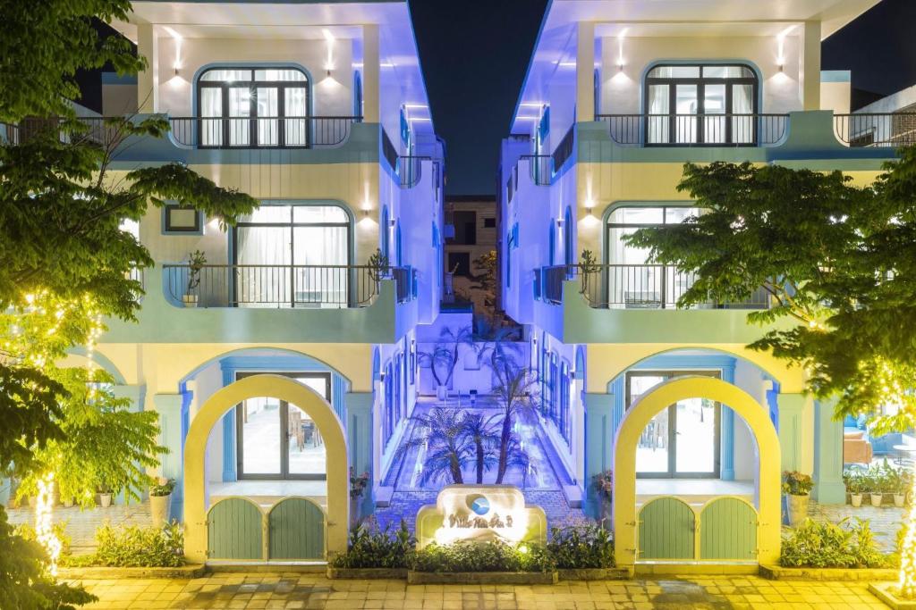 岑山Villa FLC Sầm Sơn BT VIP Phong Cách Địa Trung Hải的蓝色的建筑,前面有一个喷泉