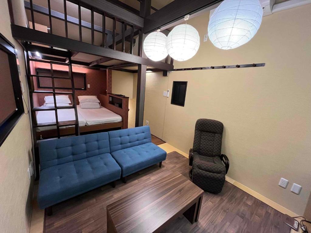 东京Japanese Modern House in Shinagawa的客厅配有蓝色的沙发和床。