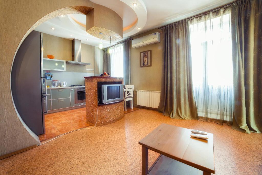 车里雅宾斯克Five Stars Comfortable Kvartira的一间带桌子和电视的客厅以及一间厨房。
