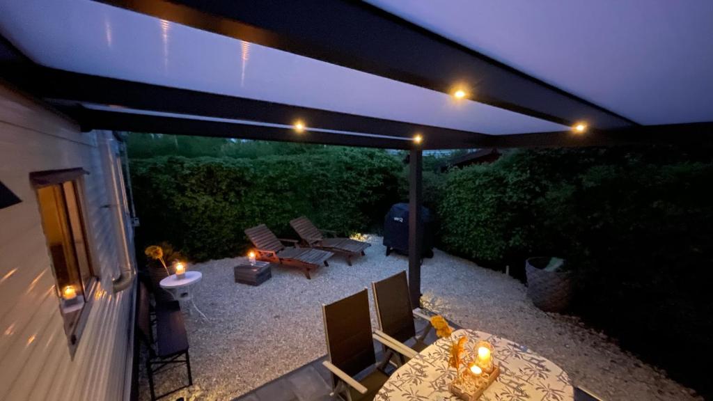 HoekPURE - Chalet Zeeland - garden out of sight的天井配有桌椅和灯