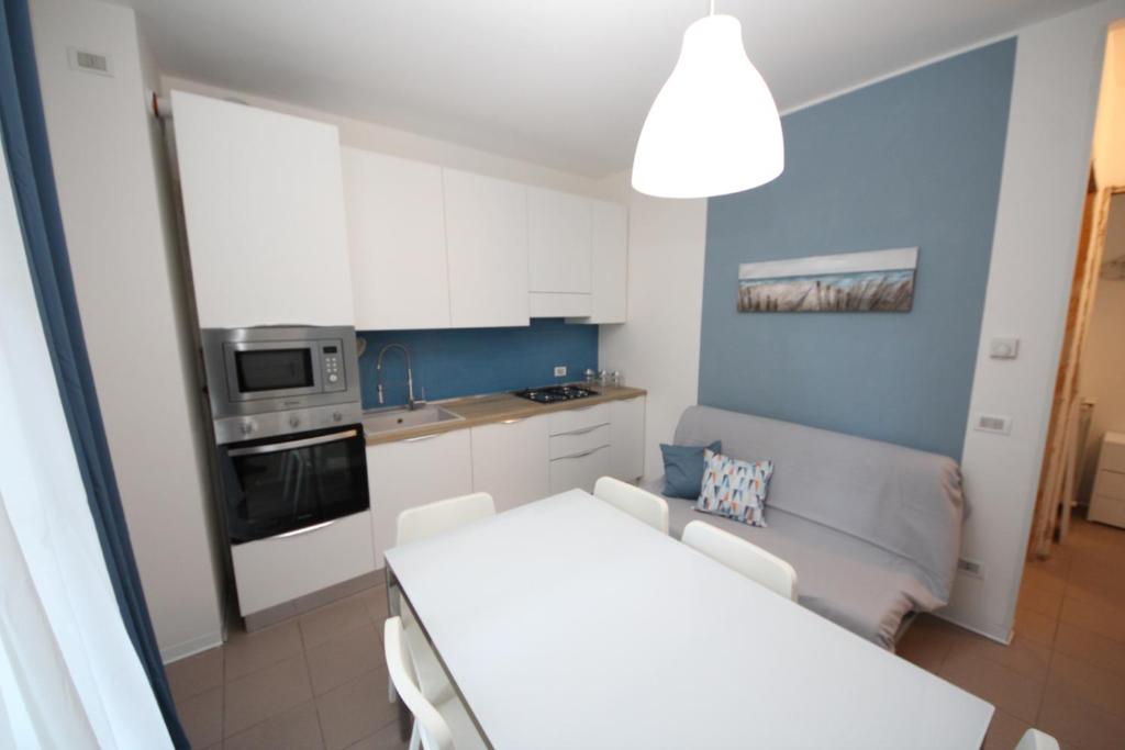 罗索利纳马雷Residence Verdena appartamento 02的小厨房配有白色的桌子和沙发