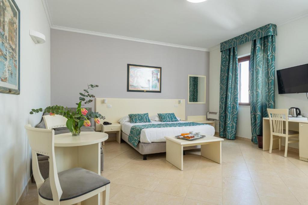 阿尔卡莫Hotel Centrale Spa & Relax的酒店客房配有一张床铺、一张桌子和一张书桌。