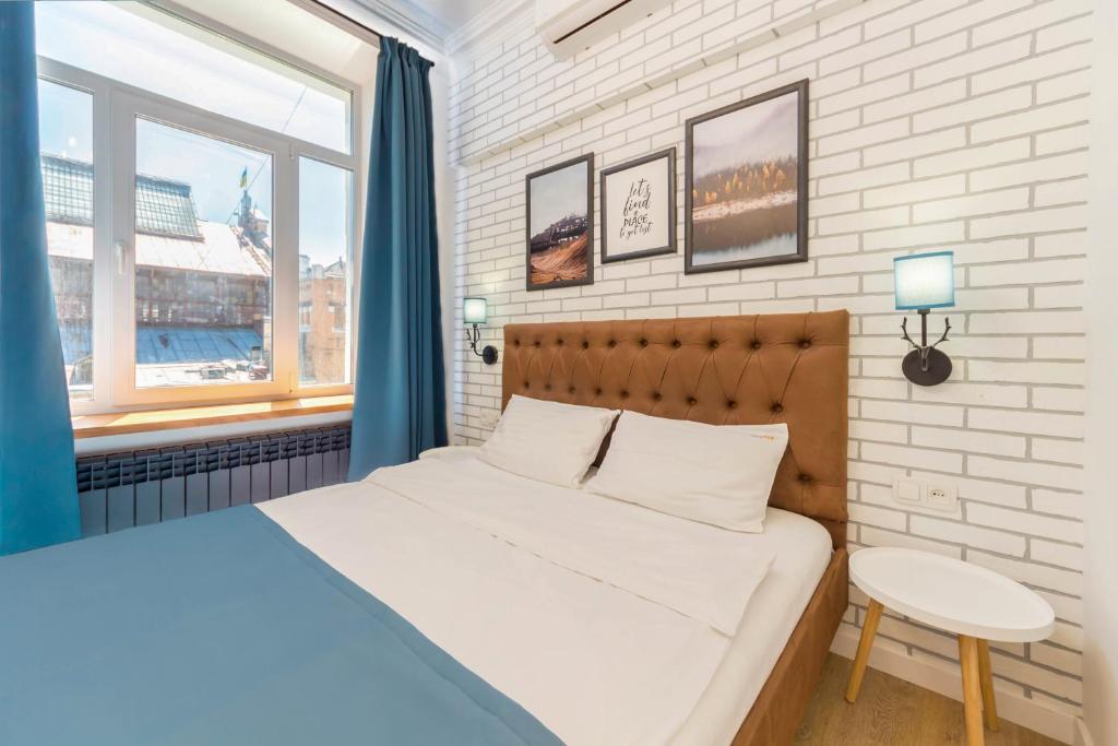 基辅Scandinavian Apartments的一间卧室配有一张床、一张桌子和一个窗户。
