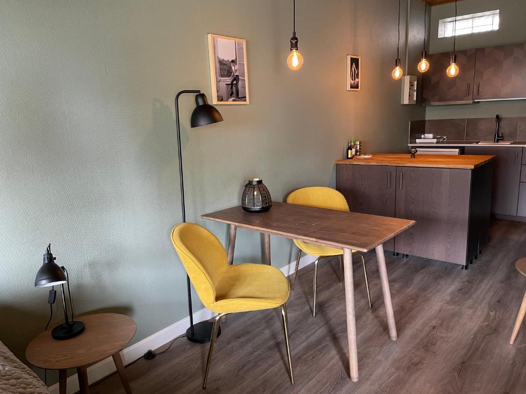 巴勒鲁普Jonstrupvejens Apartments Lejl C的厨房配有桌子和2把黄色椅子